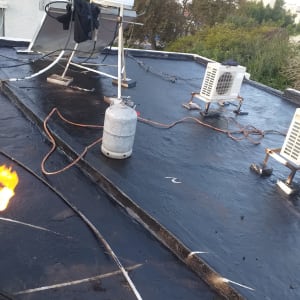 גג עם יריעות איטום, בלון גז וצינור להבה