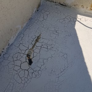 ציפוי אטימה סדוק על גג עם צינור מתכת