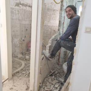 אדם עובד על שיפוץ קיר עם מקדחה