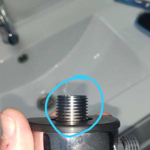 חלק מתכת עם הברגה ביד של אדם