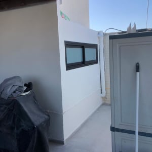 חלון אלומיניום שחור בקיר חיצוני לבן