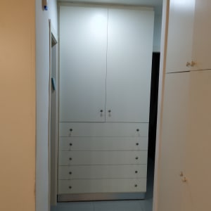 ארון לבן עם דלתות ומגירות בעבודת נגרות