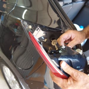 תיקון פנס אחורי של רכב על ידי אדם