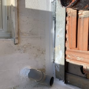 צינור פלסטיק אפור על גג עם רעפים