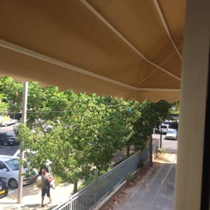 סוכך חום עם קורות לבנות מעל רחוב