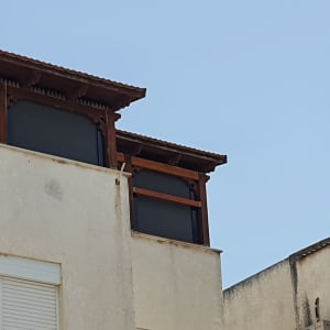 סוככים כהים על גג מבנה עם מסגרת עץ