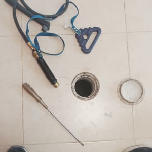 כלי עבודה וצינור ליד פתח ביוב פתוח