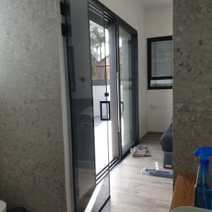 דלת זכוכית פתוחה עם ידית מתכת שחורה