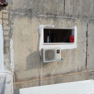 יחידת מזגן חיצונית מותקנת על קיר בטון