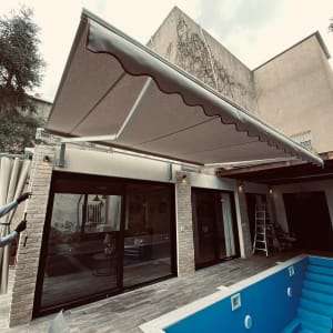 אדם מתקין סוכך חיצוני מעל מרפסת