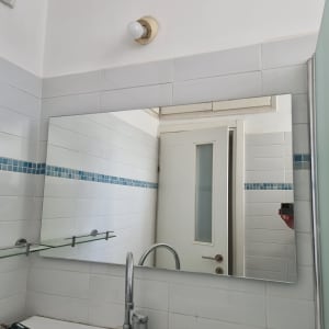 מראה גדולה על קיר עם מדף זכוכית