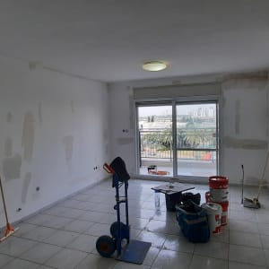 חדר בשיפוץ עם דליים, כלי עבודה ומטאטא