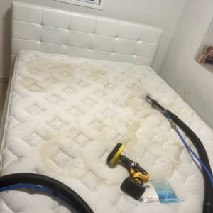 מזרן עם כתמים, מכונת ניקוי צהובה וצינור שחור