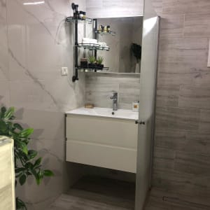 כיור לבן עם מראה, מדפים ותאורה בחדר אמבטיה