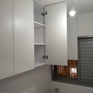 ארונות מטבח לבנים עם דלת פתוחה