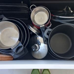 סירים ומחבתות מאורגנים במגירה במטבח