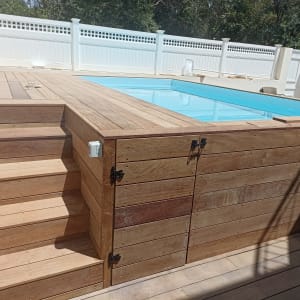 דק עץ מסביב לבריכה עם מדרגות