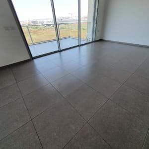 רצפה נקייה עם אריחים גדולים ליד חלון זכוכית