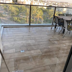 מעקה זכוכית במרפסת עם נוף לעיר