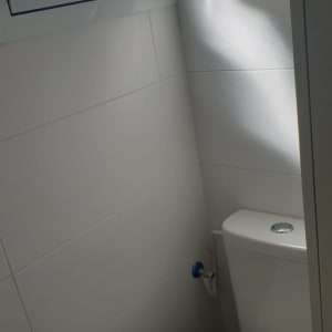 שירותים עם חלון קטן וקיר אריחים לבנים