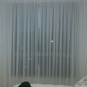 וילון לבן שקוף תלוי על חלון גדול