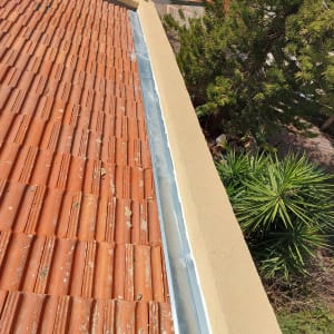 רעפים אדומים עם תעלה מתכתית לאורך הגג