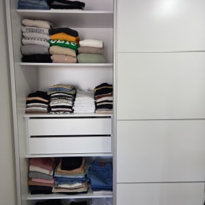 ארון בגדים מסודר עם בגדים מקופלים על מדפים