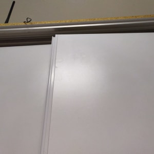 דלת הזזה לבנה עם מסגרת מתכת עליונה