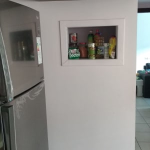 מוצרים על מדף גבס במטבח, כולל בקבוקים וצנצנות