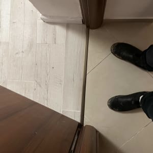 דלת עץ פתוחה עם משקוף חום ורצפה שונה משני הצדדים