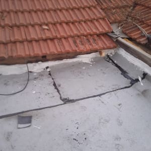 איטום גג עם חומר לבן ליד רעפים אדומים