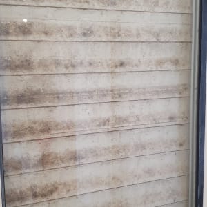 חלון מלוכלך עם אבק ולכלוך על התריסים