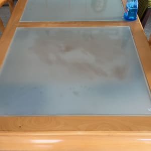 שולחן זכוכית עם בקבוק תרסיס כחול