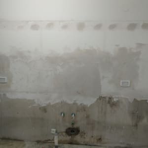 קיר עם טיח מתקלף ושקעים חשמליים