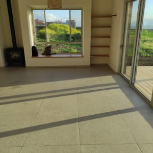 רצפה נקייה עם אור שמש חודר דרך חלון גדול