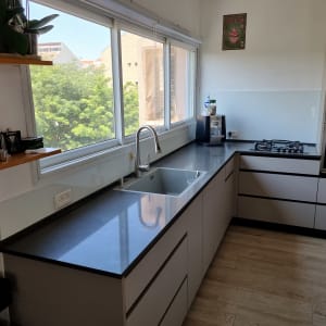 חלון זכוכית גדול במטבח מודרני עם כיור וברז