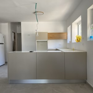 מטבח עם מקרר, אי, חלונות ובקבוק פלסטיק