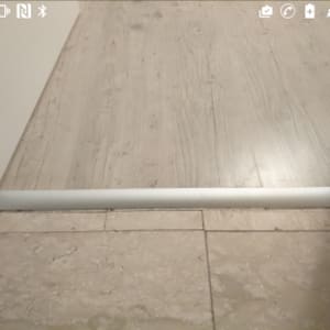 חיבור בין פרקט לרצפת אבן עם פס מתכת