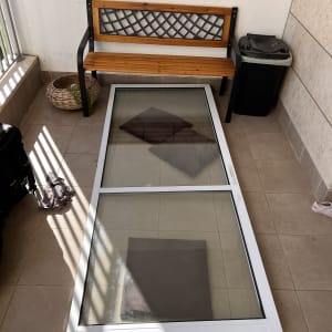 חלון עם תריסים מונח על הרצפה במרפסת