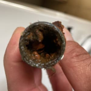 צינור חלוד עם סתימה מוחזק ביד