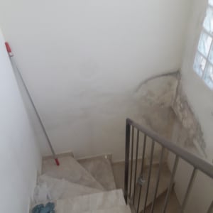 מקל צבע על קיר מדרגות עם כתמי רטיבות