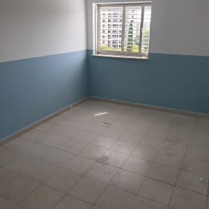 חדר ריק צבוע בשני גוונים, לבן וכחול, עם חלון במרכז הקיר