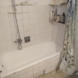 אמבטיה עם אריחים שבורים ועובש על הקיר