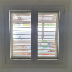 חלון אלומיניום עם תריסים פתוחים למחצה