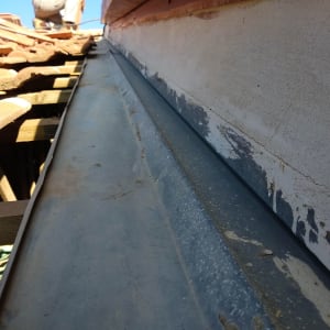 אדם עובד על גג עם רעפים ומתכת