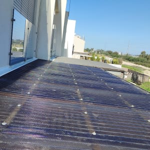 גג עם לוחות סולאריים ליד גינה
