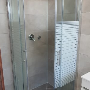 מקלחון זכוכית עם דלתות הזזה וברז מתכת