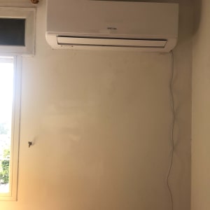 מזגן מותקן על קיר עם כבל חשמל תלוי