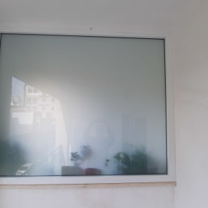 חלון עם מסגרת אלומיניום על קיר לבן