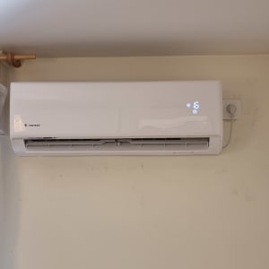 מזגן קיר לבן עם תצוגת טמפרטורה דיגיטלית